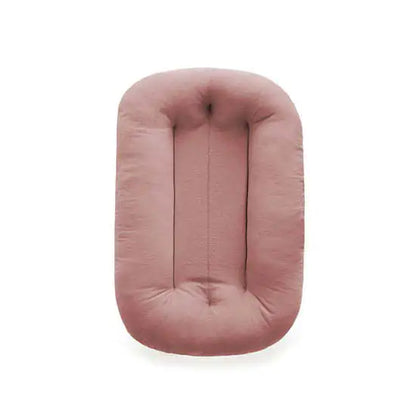 Pink lightweight bionic baby bed with side handles for easy travel and transport.